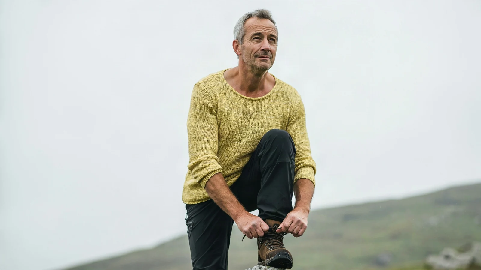 A man in his fifties tying a hiking boot