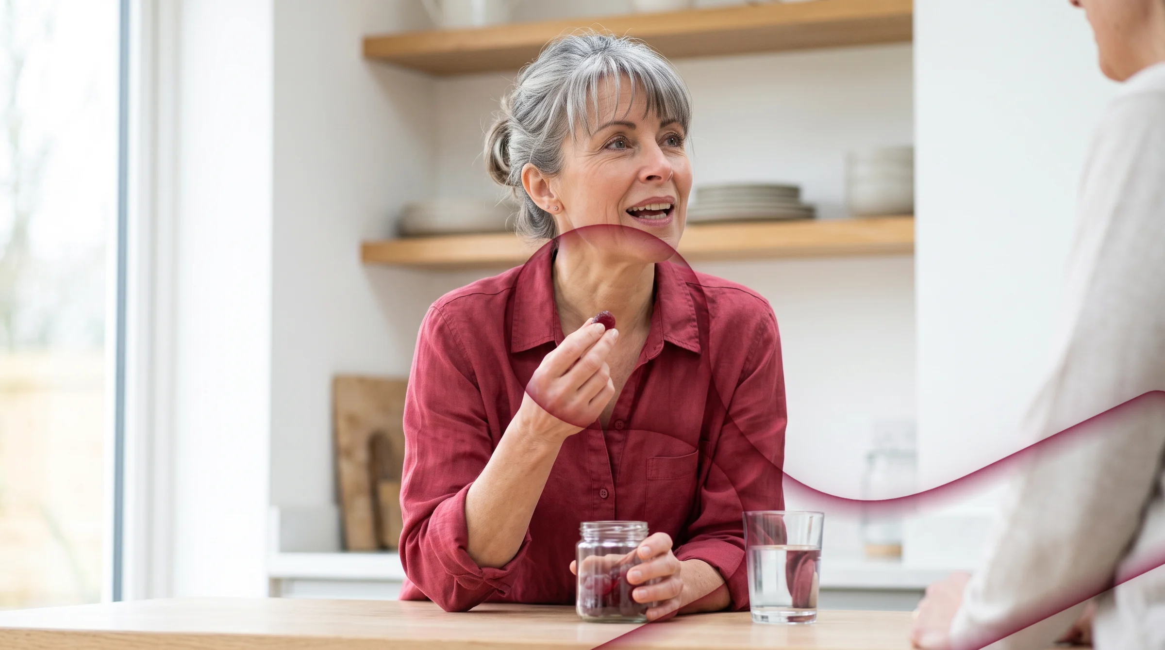 The same woman in her kitchen, taking a gummy from a glass jar