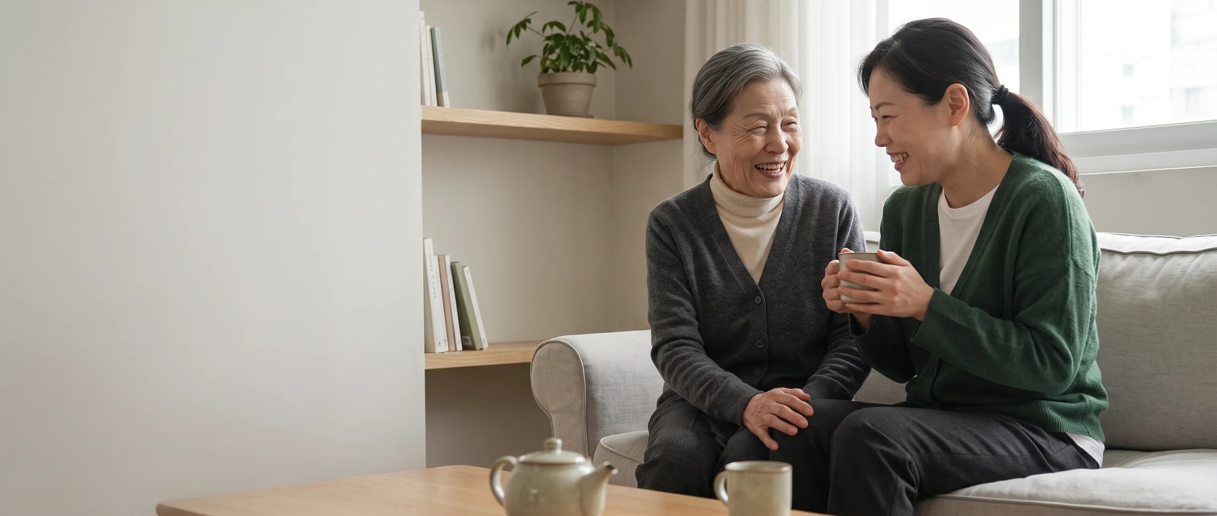 The same mother and daughter laughing together on the sofa